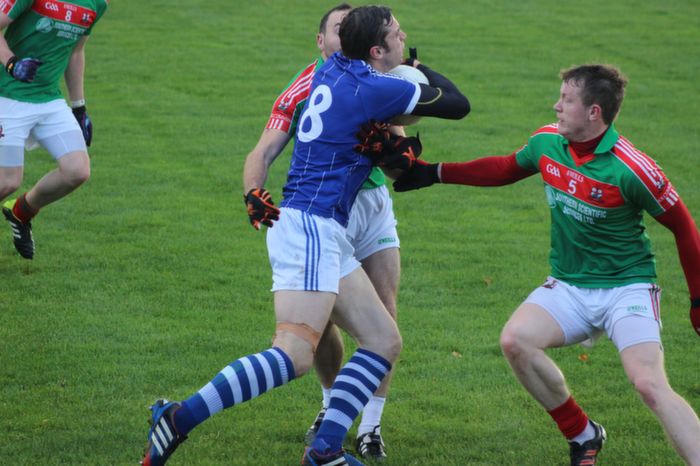David Moran, being closely marshaled by two Kilcummin players. Photo by Gavin O'Connor.  