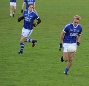 David Moran watches Giles O'Grady as he solos out up the field against Kilcummin. Photo by Gavin O'Connor. 