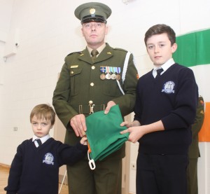 Receiving the Irish flag from Sgt Denis McGarry were Blennerville National School pupils, Issac Price and Tomas O'Sullivan. Photo by Gavin O'Connor. 