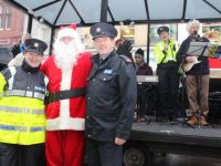 Garda Cathy Murphy with Santa and Inspector Donal Ashe face the camera while Garda Mary Gardiner belts out a tune during fundraising activities on The Mall on Wednesday. Photo by Dermot Crean
