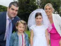 Caherleaheen NS pupil Emma O'Donoghue with parents Alan and Lisa and sister Ava at the Church of the Immaculate Conception in Rathass on Saturday. Photo by Dermot Crean