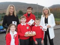 Minister Norma Foley with Bríd Nic Gearailt and Mary Wallace of Derryquay NS and pupils Édana Kingston, Dylan Passway and Jayden Sinnott holding a biscuit cake, the recipe for which came from Minister Foley herself. Photo by Dermot Crean