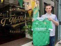 Tony McMahon with the signed Kerry GAA jersey at his barbershop on Russell Street. Photo by Dermot Crean